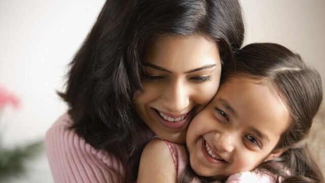 a mother and a daughter hugging and smiling