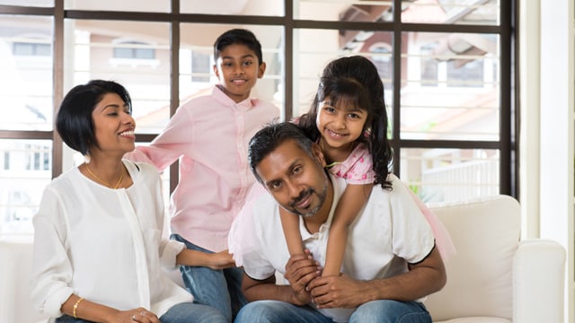 a father, mother, son, and daughter on the couch smiling