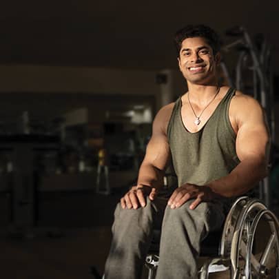 A wheelchair bodybuilder with a bright colgate smile