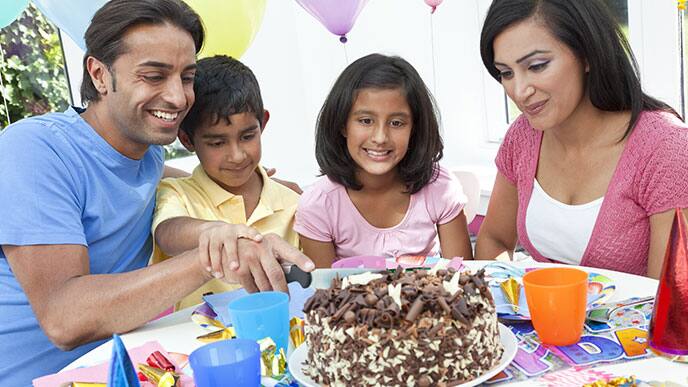 Family eating a large piece of cake together