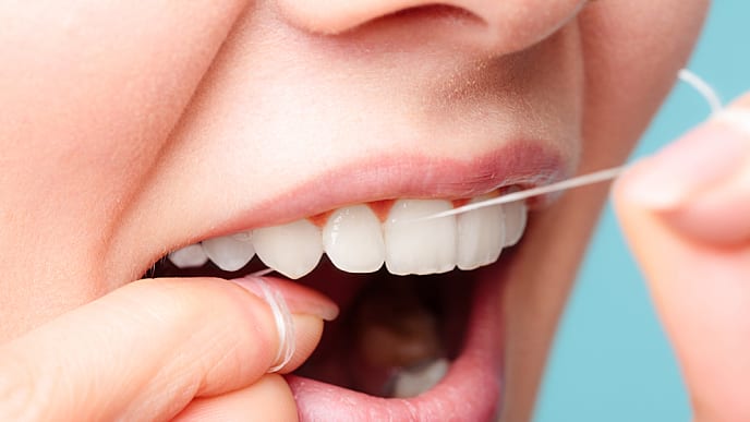 water flossing vs normal flossing - colgate in