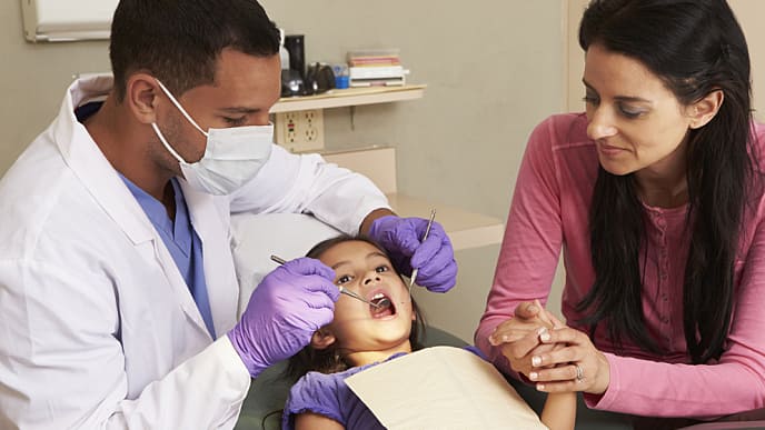 young girl having check up with a dentist for children