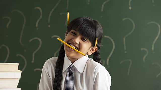 a young girl student with pencil on her hair and bitting a pencil