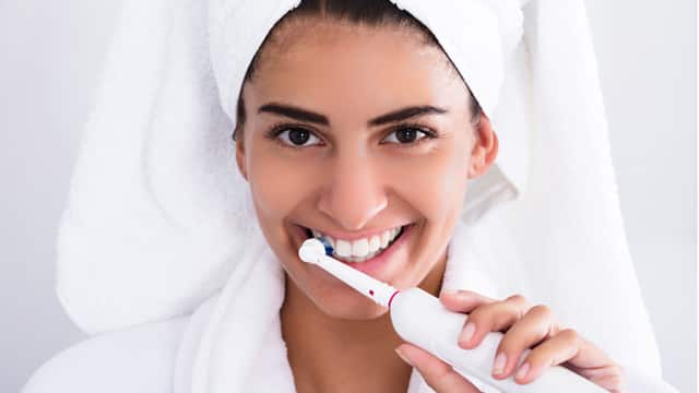 Woman using an electric toothbrush