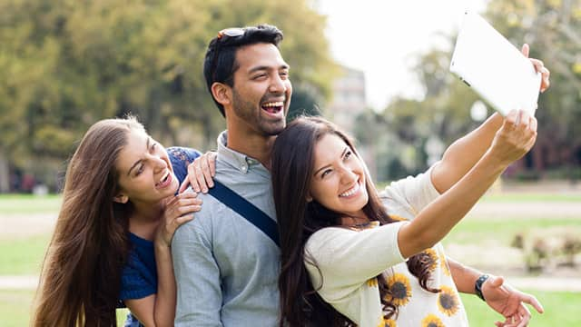 man and two women smiling taking a group photo