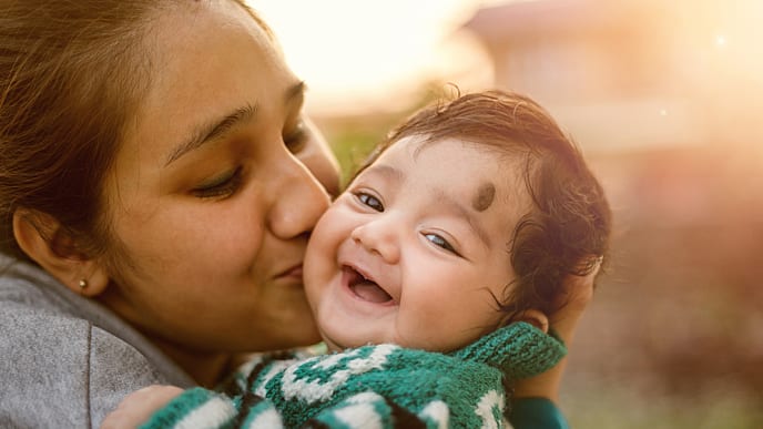 indian mother kissing her baby