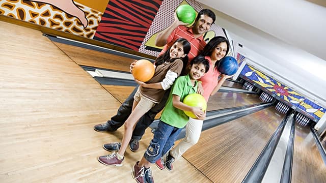 a happy family smiling while bowling