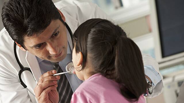 Pediatric dentist examing a girl teeth