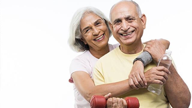 an elderly couple smiling wearing workout clothes