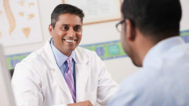 A male doctor smiling in front of a male patient