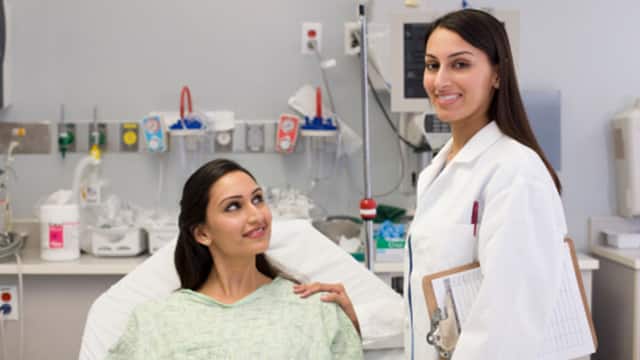 A female dentist and female patient smilling