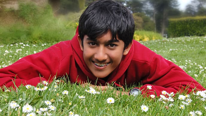 boy with retainers for teeth having fun in a garden