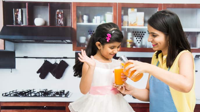 Mother pouring juice for her daughter