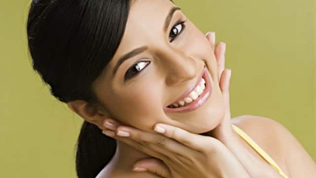 woman smiling with her hands on her cheeks