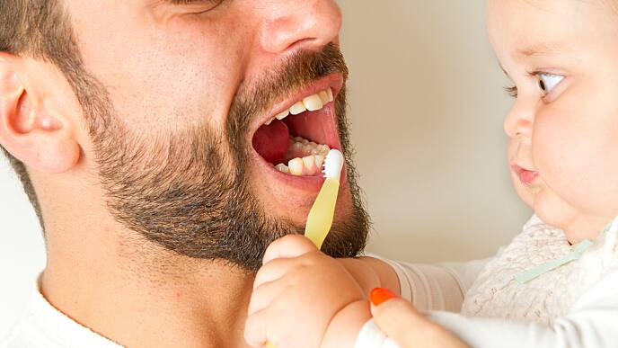 Baby cleaning teeth daddy