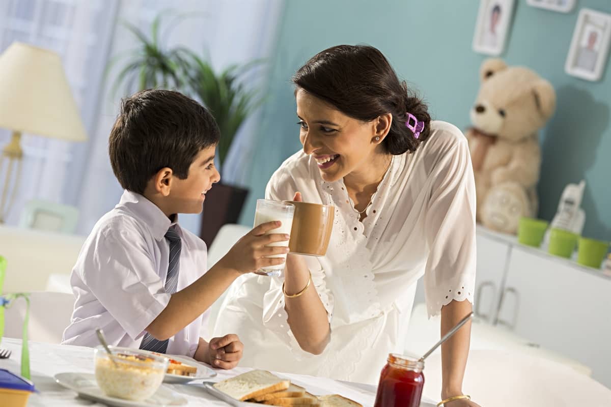 Woman and her son drinking a cup of milk