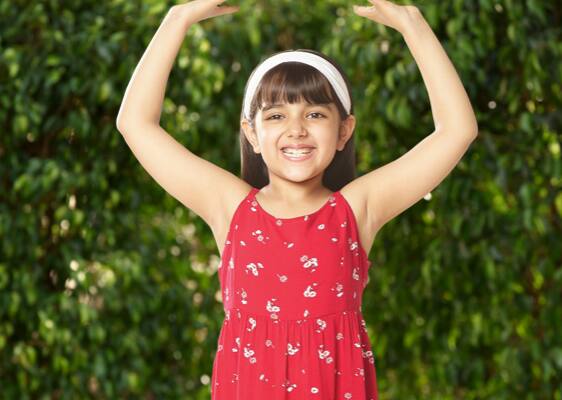 girl smiling with her hands up