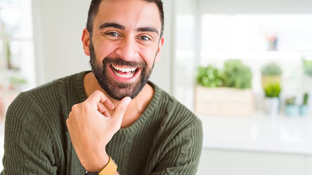 Handsome man smiling cheerful with a big smile on face showing teeth, positive and happy expression