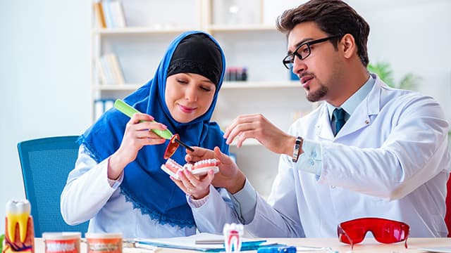 Dentist doctor and assistant working on new tooth implant