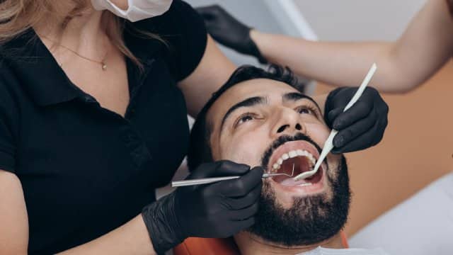 dentist-examining-patients-teeth-clinic