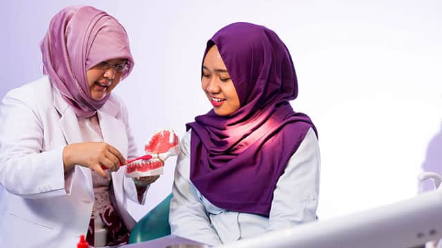 portrait hijab female dentist demonstrate how
