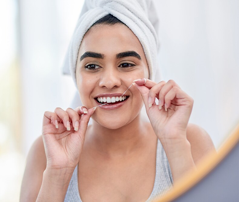 woman using colgate total floss 