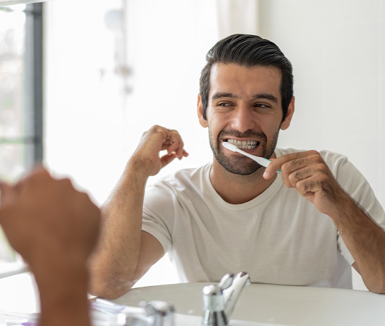 men brushing his teeth with colgate total plaque pro release