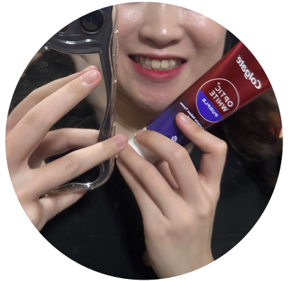A smiling woman with Colgate Optic White Purple Toothpaste A smiling woman with Colgate Optic White Purple Toothpaste