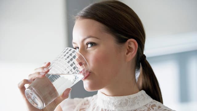 woman drinking water from a glass