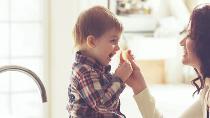  Happy mother and her child playing on the carpet at home