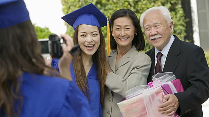 Parents taking a picture with daughter at graduation ceremony 