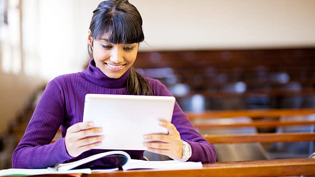 a girl is looking at her ipad and studying orthodontics