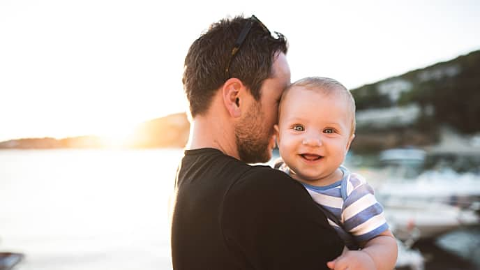 father is hugging happy baby after cleaning baby's teeth with glycerin