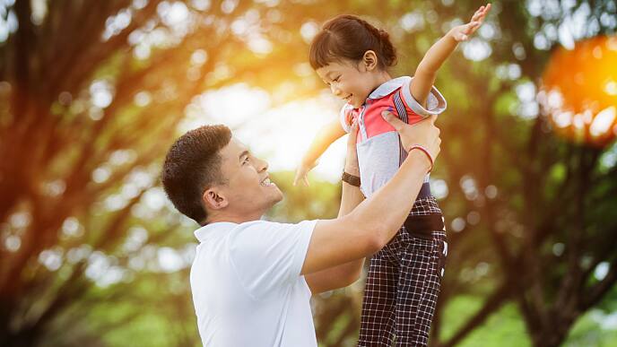  father playing with his daughter in park