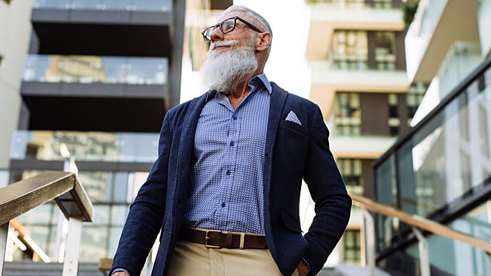 A man in casual suits standing outside