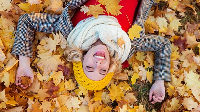 Girl lying on fallen yellow leaves