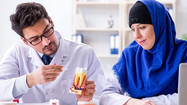 Dentist doctor and assistant working on new tooth implant