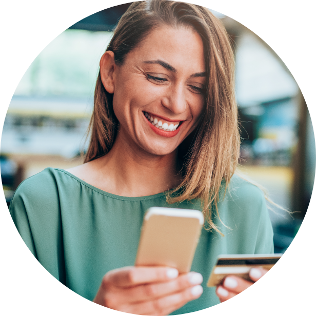 Woman in Green Shirt Looking at Cell Phone and Credit Card