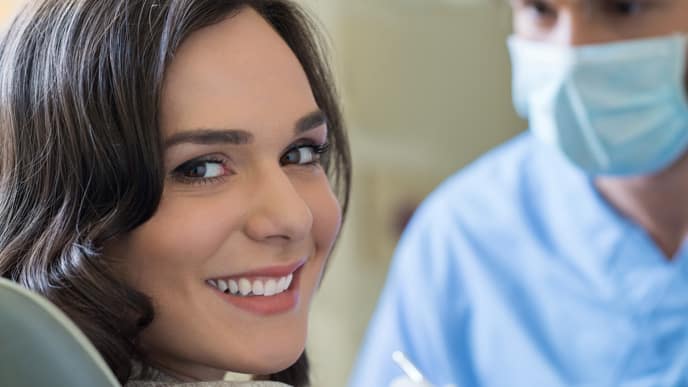 Mujer con hermosa sonrisa en cita odontológica