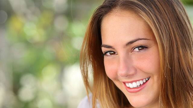 Joven con dientes blancos y brillantes sonriendo