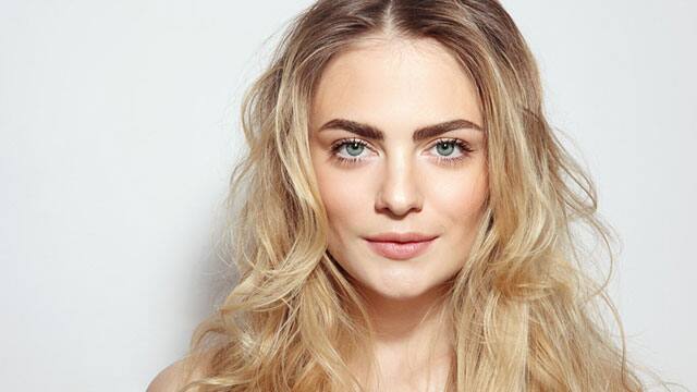 Young woman is smiling with close mouth