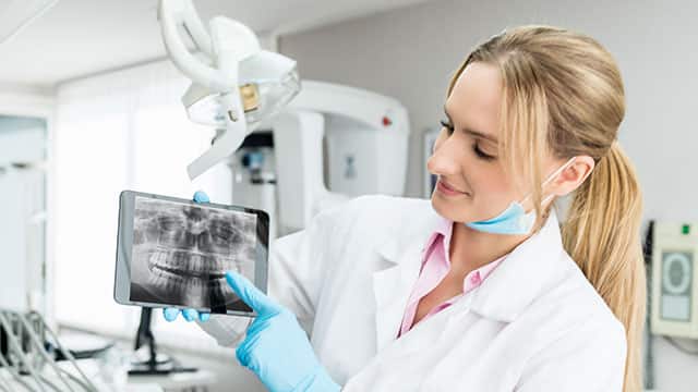 Dentista explicando radiografía dental