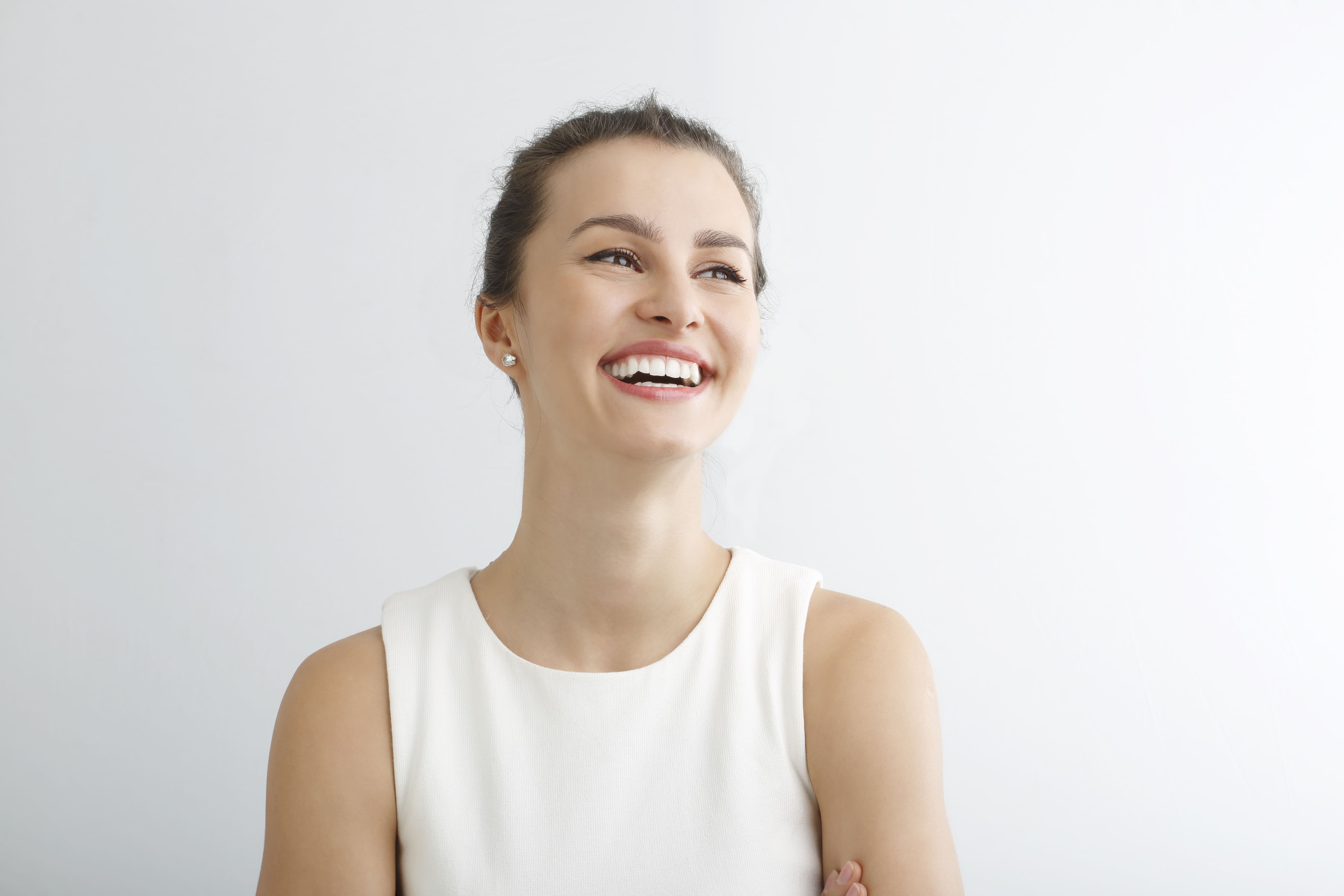 woman in white tank top smiling