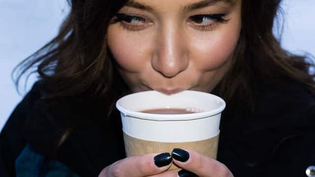 Woman drinking coffee, one of the causes of teeth staining