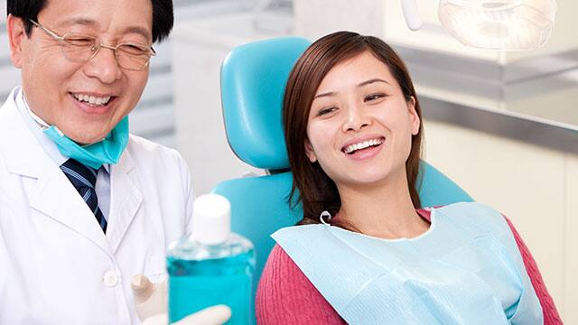 A doctor is showing a bottle of the mouthwash to the female patient