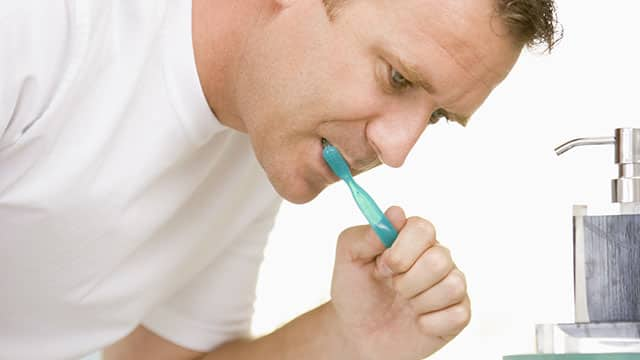 A man is brushing his teeth