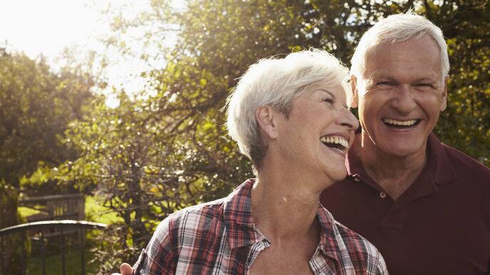 Senior couple laughing in front of lake