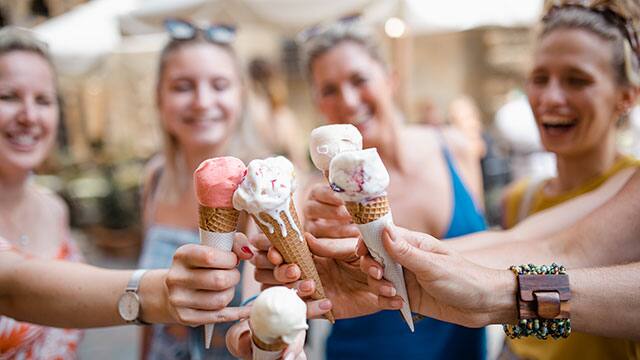 A close up of the ice cream cones held by group of women A close up of the ice cream cones held by group of women