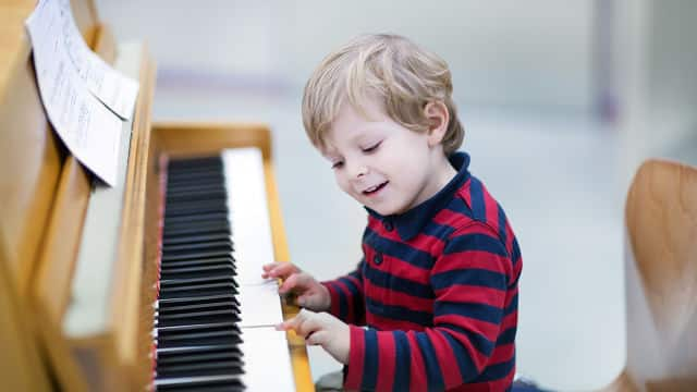 Happy boy playing piano