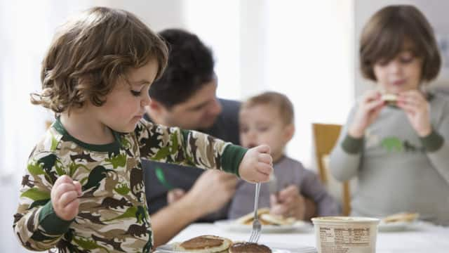 Niños comiendo pancakes con chocolate